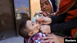 FILE - A boy receives polio vaccine drops during an anti-polio campaign in Peshawar, Pakistan, Feb. 17, 2020. 