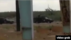 تصویری از ویدئویی که نیروهای نظامی مسلح با دوشکا و سلاح های سنگین را در حال تیراندازی در نیزار ماهشهر نشان می دهد