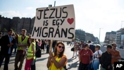 People take part in a demonstration in support of migrants, called Solidarity Day, at the Keleti railway station in Budapest, Hungary, Saturday, Sept. 12, 2015.