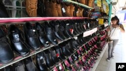 FILE - A woman is seen browsing for shoes at a store in downtown Chiang Mai, northern Thailand.