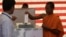 Cambodian Buddhist monk, right, casts his ballot in local elections at Wat Than pagoda's polling station in Phnom Penh, Cambodia, Sunday, June 3, 2012. 