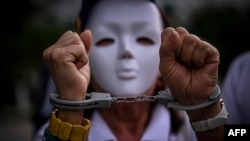 FILE - A handcuffed women attends a rally to protest the Venezuelan July 28 disputed presidential election in Panama City, Sept. 28, 2024. The rally was one of several held outside Venezuela.