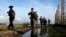 Myanmar police officers patrol along the fence bordering Bangladesh in Maungdaw, Rakhine State, Myanmar, Oct. 14, 2016. New reports accuse soldiers of brutality against Myanmar's long-persecuted Rohingya Muslims.