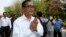 Cambodian main opposition Cambodia National Rescue Party leader Sam Rainsy, front, greets his supporters as he arrives at Choeung Ek memorial on the outskirts of Phnom Penh, Cambodia, Friday, May 17, 2015. 