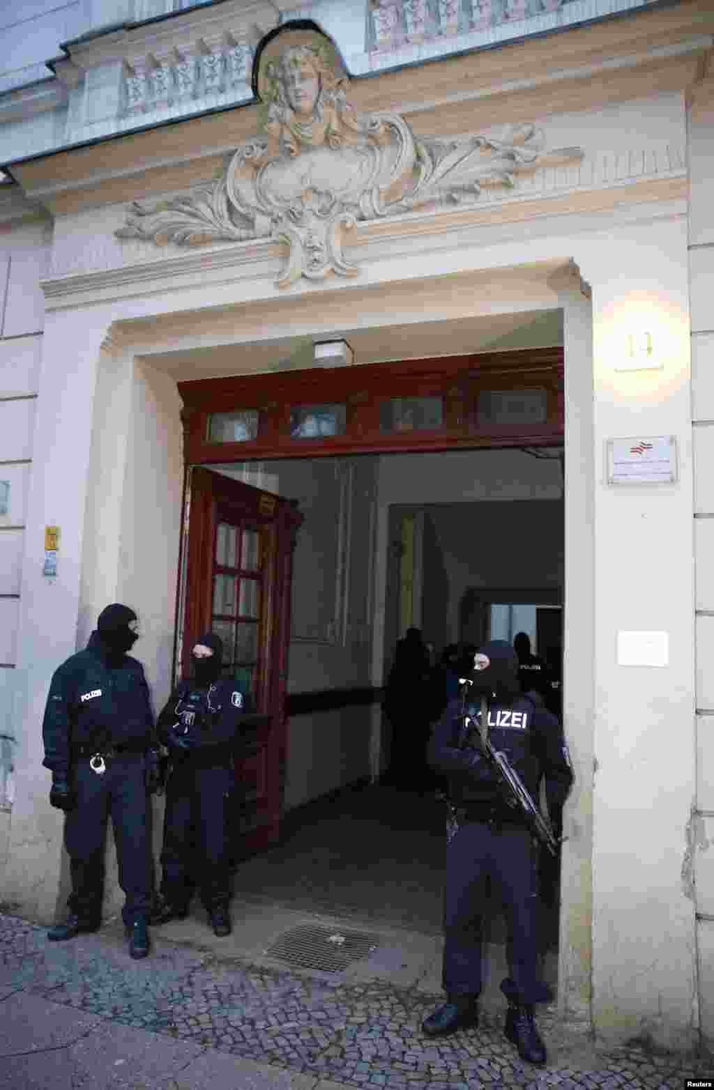 German special police units guard an entrance to an apartment building in the Wedding district of Berlin, Germany, Jan. 16, 2015.