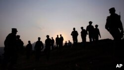 FILE - Pakistan army soldiers gather at a forward area post on the Line of Control (LoC) that divides Kashmir between Pakistan and India, in Tatta Pani, Pakistan, Oct. 1, 2016. On Monday, Pakistan's army claimed that Indian troops opened fire across the LOC, killing at least seven soldiers.