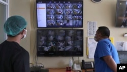 FILE - Dr. Irman Pahlepi (kiri), memeriksa layar monitor pasien di Rumah Sakit Umum Dr. Suyoto, Jakarta, 29 Juli 2021. (Tatan Syuflana/AP)