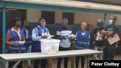 Observers from the African Union examine ballots at the Ridge Church polling center in Accra, Ghana, Dec. 7, 2020. The AU team was led by Kgalema Motlanthe, former president of South Africa. (Photo: Peter Clottey, Issa Ali / VOA) 