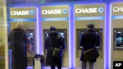 FILE - Customers uses ATM's at at a branch of Chase Bank.
