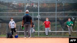 Children wearing face masks attend baseball practice at Pan Pacific Park amid the coronavirus pandemic, Nov. 6, 2020, in Los Angeles, California.