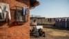 Two men rest outside the Tsolo Community Hall in Johannesburg's Katlehong township, Sept. 9, 2019, where around 250 people, are hosted after being displaced by anti-foreigner violence that hit South Africa's financial capital.