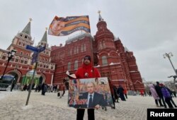 A supporter of Russian President Vladimir Putin distributes newspapers in Moscow