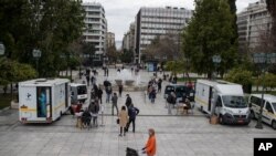 Medical staff of the National Health Organisation (EODY) conduct rapid tests for the COVID-19 as people queue in Syntagma square, central Athens, March 7, 2021.