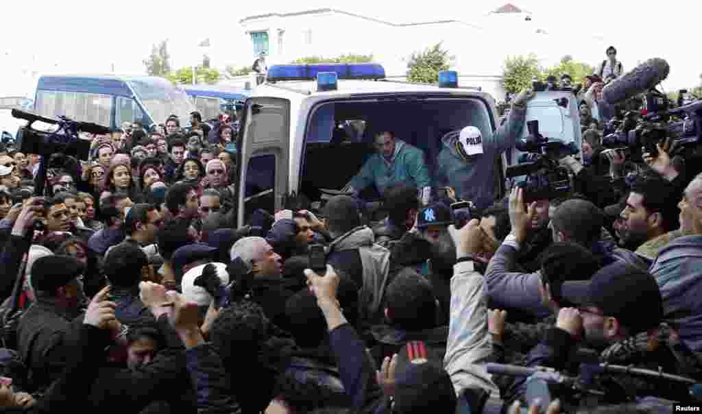 The body of Chokri Belaid, a prominent Tunisian opposition politician, is carried into an ambulance after he was shot, in Tunis Feb. 6, 2013.