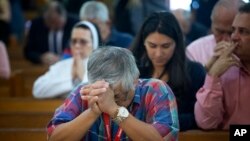 FILE - People pray as the church discuss the Supreme Court hearing arguments regarding the U.S. Constitution requiring states to allow same-sex marriages, April 29, 2015 in Miami. On Feb. 12, 2018, a gay schoolteacher has been fired by a Miami Catholic sc
