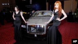 អ្នក​បង្ហាញ​ម៉ូដ​ឈរ​ថត​ក្បែរ​រថយន្ត Rolls-Royce Wraith មួយ​គ្រឿង​ក្នុង​អំឡុង​ពិធី​សម្ពោធ​ការ​បើក​លក់​នៅ​រាជធានី​ភ្នំពេញ​កាល​ពី​ថ្ងៃ​ទី​៩​ ខែ​ឧសភា ឆ្នាំ​២០១៤។