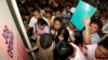 FILE - Filipino job seekers look at job openings posted on a board inside a Philippine Overseas Employment Agency (POEA) in Manila.