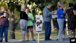 FILE - Voters stand in line to vote at an early voting polling site in San Antonio, Texas, on Oct. 20, 2014. The U.S. Supreme Court will hear arguments Tuesday in a "one person, one vote" case stemming from Texas.
