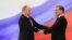 Russian President Vladimir Putin, left, and former President Dmitry Medvedev shakes hands at the inauguration ceremony. 