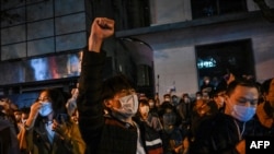 People sing slogans while gathering on a street in Shanghai on Nov. 27, 2022, where protests against China's zero-COVID policy took place following a deadly fire in Urumqi, the capital of the Xinjiang region.