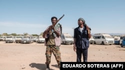 Des membres de la milice Amhara posent pour un portrait à l'entrée du 5e bataillon du commandement nord de l'armée éthiopienne à Dansha, en Éthiopie, le 25 novembre 2020.