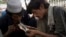 FILE - Pakistani drug addicts smoke heroin in Rawalpindi, June 26, 2013. 