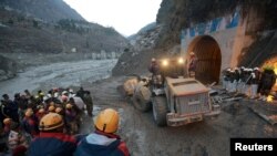 Members of Indo-Tibetan Border Police (ITBP) watch as a machine is used to clear a tunnel 