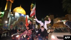 ประชาชนร่วมชุมนุมในกรุงเตหะรานพร้อมโบกธงชาติอิหร่านและธงปาเลสไตน์ หลังจากอิหร่านเปิดฉากโจมตีอิสราเอลเมื่อวันที่ 14 เมษายน 2024 