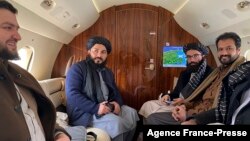 នៅក្នុង​រូបថត​ដែល​ចេញផ្សាយ​ដោយ​ពួកតាលីបង់​អាហ្វហ្គានីស្ថាន និង​ថត​នៅ​ថ្ងៃទី២២ ខែមករា ឆ្នាំ២០២២ បង្ហាញ​អំពី​សមាជិក​មន្ត្រី​ជាន់ខ្ពស់​តាលីបង់​លោក Anas Haqqani (ស្តាំ) និង​គណៈប្រតិភូ កំពុង​អង្គុយ​នៅ​លើ​យន្តហោះ​មុនពេល​ចេញ​ដំណើរ​ទៅ​កាន់​ទីក្រុងអូស្លូ។