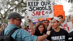 FILE - In this Wednesday, Feb. 21, 2018 file photo, student survivors from Marjory Stoneman Douglas High School are greeted as they arrive at a rally for gun control reform on the steps of the state capitol, in Tallahassee, Fla. (AP Photo/Gerald Herbert, File)