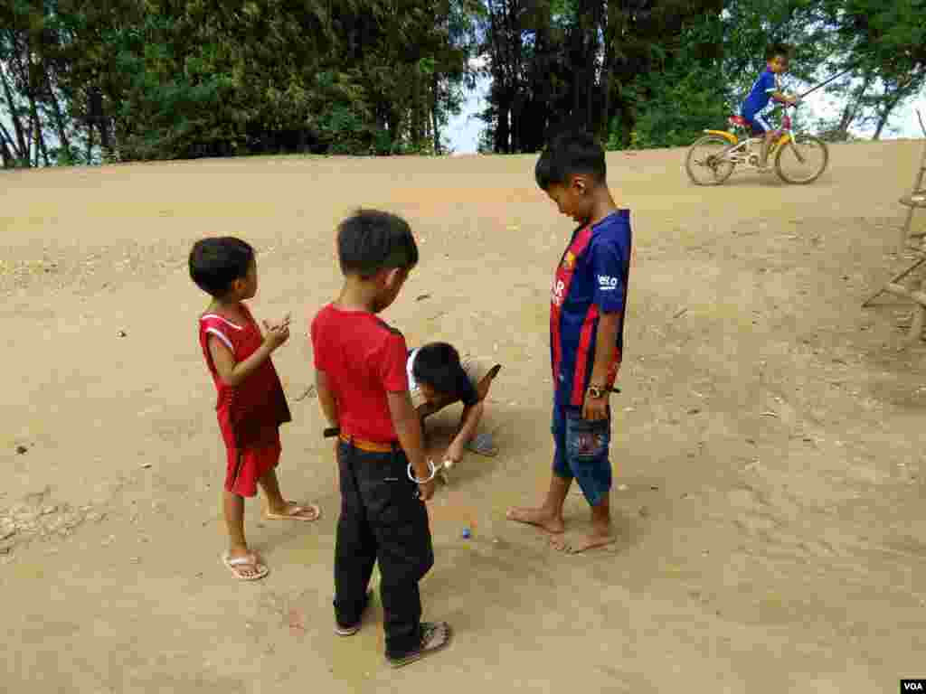 ក្មេងៗកំពុងលេងបាញ់គ្រាប់ឃ្លី នៅក្នុងភូមិស្វាយឃ្លាំង ឃុំស្វាយឃ្លាំង ស្រុកក្រូចឆ្មារ ខេត្តកំពង់ចាម នៅថ្ងៃអាទិត្យ ទី២២ ខែកក្កដា ឆ្នាំ២០១៧។ (សើ សាយ្យាណា/VOA)