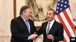 Penasihat Negara dan Menteri Luar Negeri China, Wang Yi (kanan), berbincang dengan Menteri Luar Negeri AS Mike Pompeo (kiri), sebelum pertemuan bilateral di Wisma Negara Diaoyutai, Beijing, China, 8 Oktober 2018.