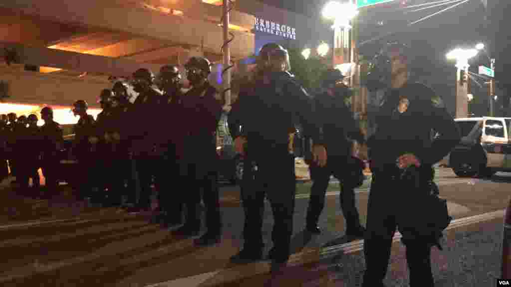 Arizona police officers activate anti-riot procedures after people report being attacked with water bottles, in Phoenix, Az., Aug. 22, 2017. (Photo: Celia Mendoza / VOA) 