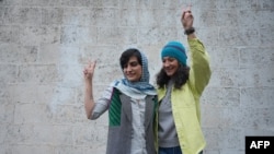 Dua jurnalis Iran Niloufar Hamedi (kanan) dan Elaheh Mohammadi menunjukkan simbol kemenangan setelah mereka berdua dibebaskan dari penjara Evin di Teheran, Iran, dengan jaminan pada 14 Januari 2024. (Foto: 