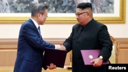 문재인 한국 대통령과 김정은 북한 국무위원장이 19일 평양 백화원 영빈관에서 평양공동선언문에 서명한 후 악수하고 있다. 사진 출처=평양사진공동취재단