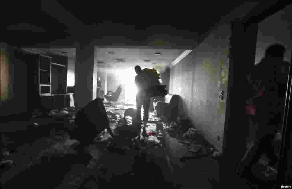 Penjarah di kantor pusat Muslim Brotherhood di distrik Muqattam di Kairo (1/7) setelah bangunan itu dibakar oleh para demonstran yang menentang Presiden Mohammed Morsi. (Reuters/Amr Abdallah Dalsh)