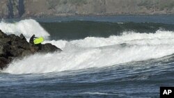 With a tsunami warning in effect for Northern California, a surfer enters the water at Fort Point near the Golden Gate Bridge in San Francisco, California, March 11, 2011