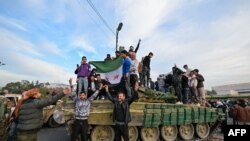 叙利亚反政府武装部队进入首都大马士革，受到群众欢迎；叙利亚军方则称阿萨德政权已结束。(法新社：2024年12月8日)