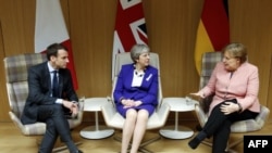 Le Premier ministre britannique Theresa May, la chancelière allemande Angela Merkel et le président français Emmanuel Macron suite à une réunion en marge du sommet des dirigeants européens à Bruxelles, le 22 mars 2018.