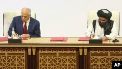 Utusan Khusus AS untuk Afghanistan, Zalmay Khalilzad (kiri) saat menandatangani perjanjian damai dengan wakil Taliban Mullah Abdul Ghani Baradar di Doha, Qatar, 29 Februari 2020 lalu. 