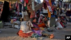 在印度艾哈迈达巴德，工人们住在路边的一棵树下休息。（2016年1月19日）