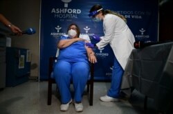 Epidemiologist Hilda Aleman reacts upon receiving the Pfizer-BioNTech COVID-19 vaccine, in San Juan, Puerto Rico, Dec. 15, 2020.