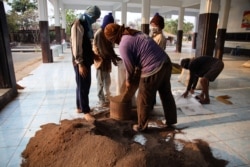 FILE - Bat guano collectors fill bags outside of a bat cave at Wat Khao Chong Phran in Ratchaburi, Thailand, March 14, 2020.