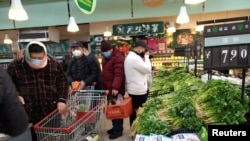 FILE PHOTO: People wearing masks shop at a supermarket on the second day of the Chinese Lunar New Year, following the outbreak of a new coronavirus, in Wuhan, Hubei province, China, Jan. 26, 2020.