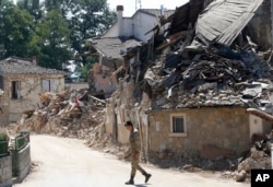 An Italian army soldier walks past rubble in Villa San Lorenzo, near Amatrice, central Italy, Aug. 27, 2016.