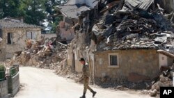 An Italian army soldier walks past rubble in Villa San Lorenzo, near Amatrice, central Italy, Aug. 27, 2016.