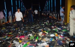 FILE - Cambodians walk through piles of shoes on a newly-built bridge where the worst stampede in their country's modern history happened, killing at least 345 people on Monday, November 22, 2010.