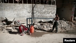 FILE - A boy fills a container with water in Zamalka, in the Damascus suburbs, Syria, 28, 2016. Recent airstrikes in the Barada Valley outside the Syrian capital seem to coincide with reports of acute water shortages in Damascus. The Barada valley provides the Syrian capital with much of its drinking water.