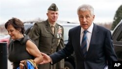 Letjen Marinir AS, Tom Waldheuser (tengah) menyambut Senator Chuck Hagel (kanan) dan istrinya Lilibet, setibanya di Pentagon, Arlington,Virginia pagi ini (27/2), untuk diambil sumpahnya sebagai Menteri Pertahanan AS.