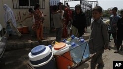 Pakistani boy carries clean water supplies from tanker, Karachi, July 2011 (file photo).